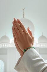 Hands in prayer gesture with mosque background, Ramadan and Islamic concept