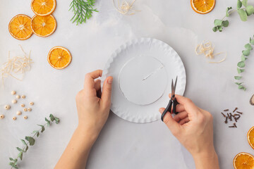 A decorative wreath crafted from dried orange slices, eucalyptus leaves, dried cloves, wooden cuts step by step instruction diy