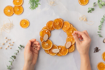 A decorative wreath crafted from dried orange slices, eucalyptus leaves, dried cloves, wooden cuts step by step instruction diy