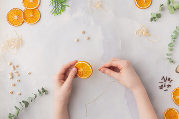 Christmas toy made from dried orange slices, wooden beads and eucalyptus leaves festive holiday interior