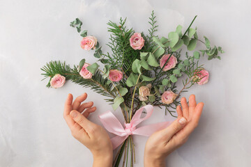 Christmas bouquet decorated with rose petals and satin ribbon &mdash; warm romantic aesthetic