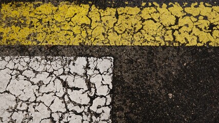 white and yellow paint line on asphalt