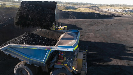 Front-end mining loader in the process of extracting and loading coal into dump trucks © WILL PHOTOGRAPHY