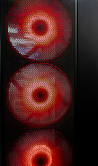 Close-up of PC cooling system behind perforated metal grille with visible fans and airflow, modern computer hardware cooling texture and technology background