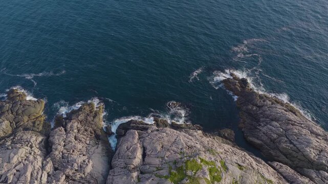 Rocky shoreline with waves crashing against steep coastal cliffs