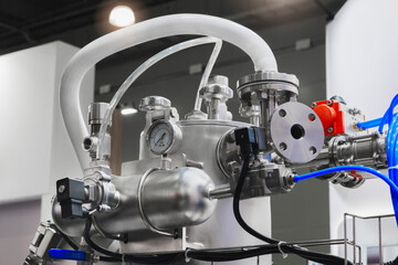 Obraz premium Large industrial machine in pharmaceutical factory with many stainless steel pipes, taps and other parts, industrial pharmaceutical concept
