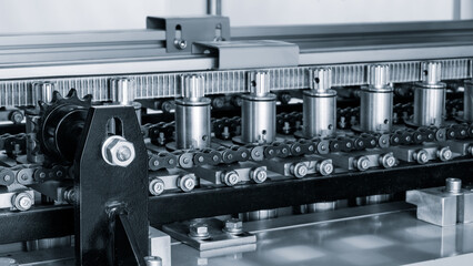 A machine for producing white plastic tubes and packaging for medicines, cosmetics, or household chemicals at a pharmaceutical cosmetics factory. Industrial concept background