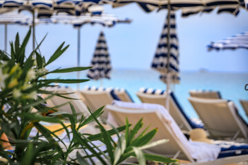 Blurred beach umbrellas and turquoise Mediterranean sea waters in Nice, France