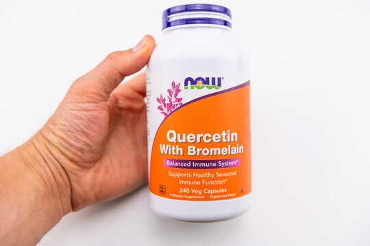 Naples, USA - May 4, 2022: Quercetin bromelain bioflavonoid enzyme supplement by Now Foods tablets pills hand holding isolated on white background