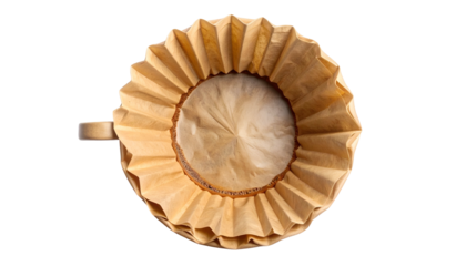 Overhead shot of a coffee filter inside a tan mug against a stark black background