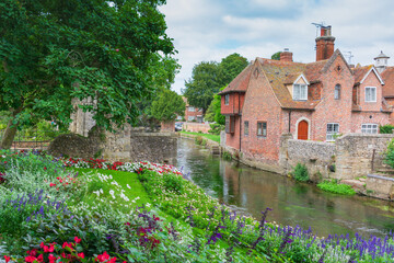 Obraz premium Historic brick cottages and colourful flower gardens along the River Stour in Canterbury, Kent.