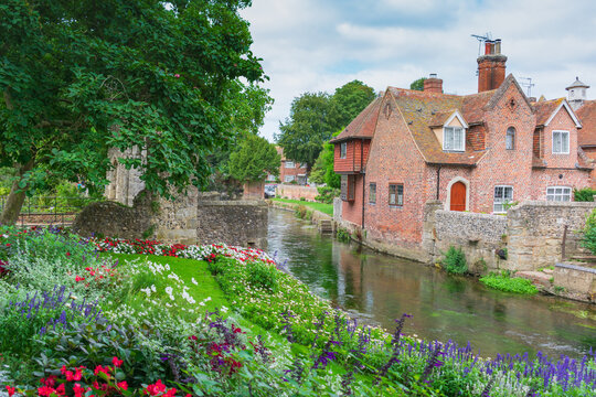 Historic brick cottages and colourful flower gardens along the River Stour in Canterbury, Kent.