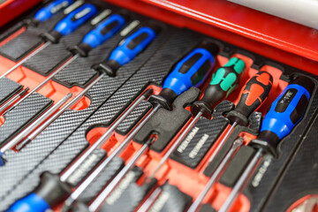 Screwdriver set arranged in a tool case showing various sizes and colors in a workshop environment