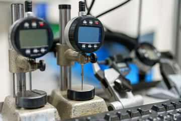 Instruments measure small distances in manufacturing lab during day time with workers present
