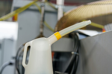 Container with flexible spout used for filling machine with liquid at workshop