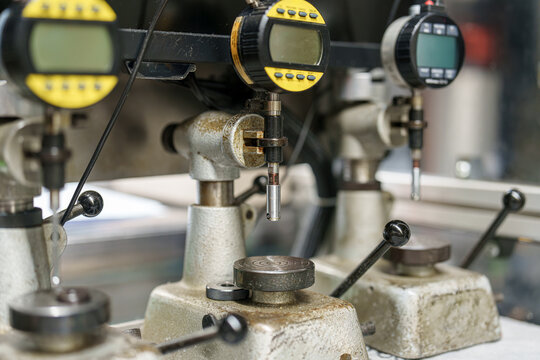 Machinery in a workshop showing devices for measuring and testing materials during industrial processes - Powered by Adobe