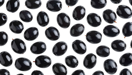 Scattered glossy black olives against a black background. Close-up photo highlights texture and shape