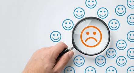 magnifying glass on sad face among smiley faces