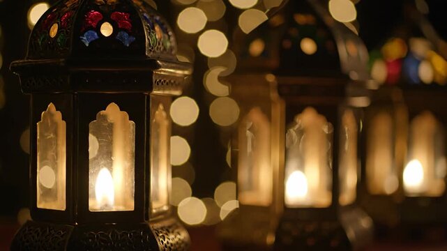 A row of ornate metal lanterns with lit candles inside, decorated with colorful stained glass patterns.
