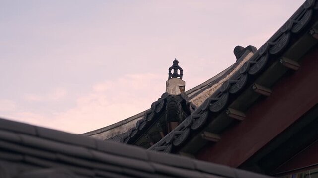 Traditional Korean Palace Roof Detail With Decorative Finial at Sunset