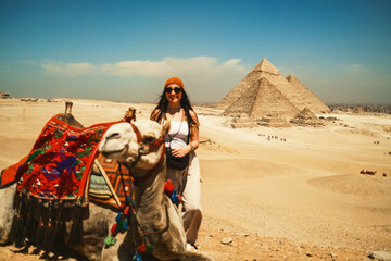 Woman With Her Camel In Front Of The Pyramids