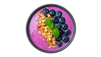 Overhead shot of a vibrant purple smoothie bowl garnished with granola, berries, and mint