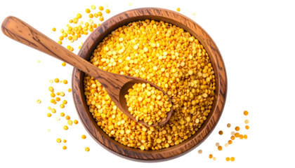 Overhead shot of a wooden bowl filled with golden granules and a spoon