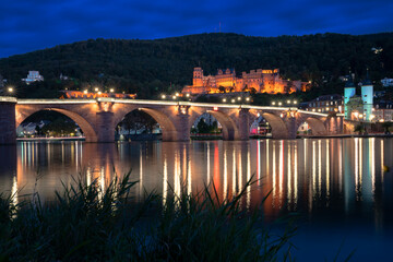 Karl Theodor Bridge and Castle in Heidelberg at Night.The old Karl Theodor Bridge and castle reflected in the Neckar River at night. Heidelberg, Germany.
