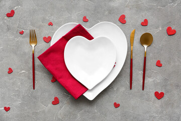 Table setting for Valentine's Day with decorative hearts on grey grunge background