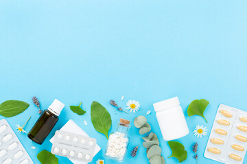 Herbs and flowers with medicines on color background, top view