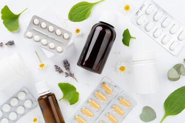Herbs and flowers with medicines on color background, top view