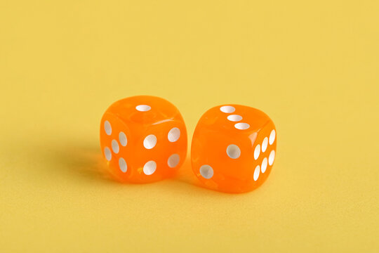 Orange game dices on yellow background