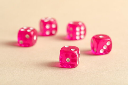 Pink game dices on beige background