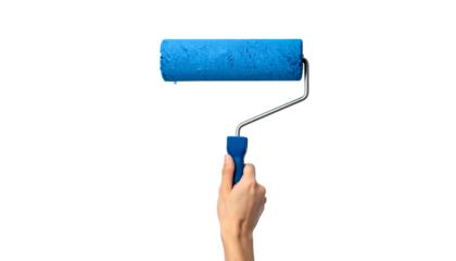 A hand holding a blue paint roller, isolated on a stark black background