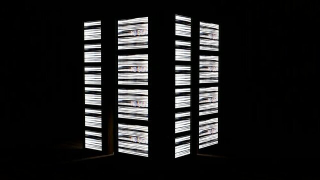 Retro tube tv in dark room behind white striped folding screen vintage delight, suitable for nostalgic design projects with a classic touch.