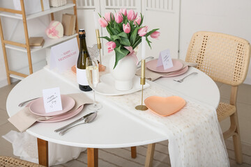 Beautiful table setting with candles, tulip flowers and wine. Valentine's Day celebration