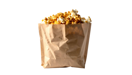 A brown paper bag overflows with buttery, caramel-colored popcorn against a black background