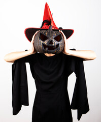 Woman wearing witch costume with pumpkin. Halloween gift. Female. Party. Background. 