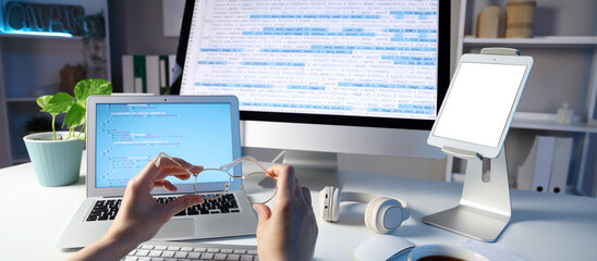 Female programmer's hands with eyeglasses at table in office, closeup