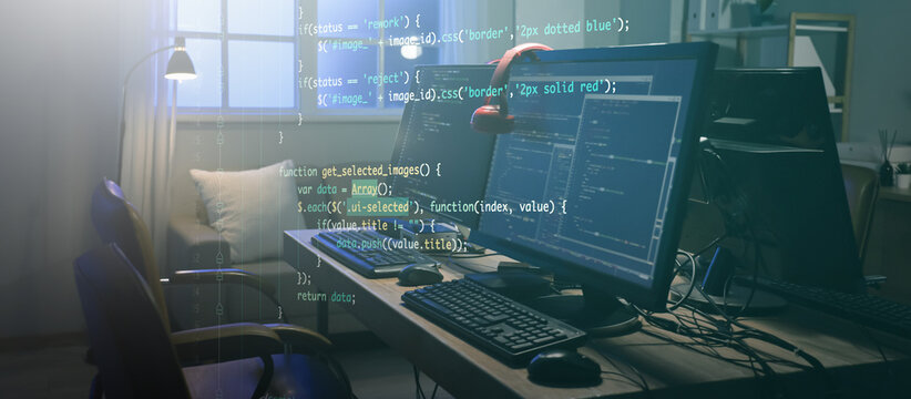 Programmer's desk with computer monitors and glowing lamps in dark office at night