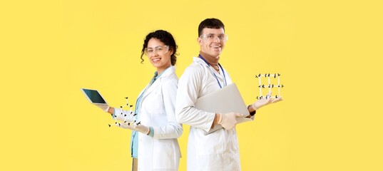 Young chemists with molecular models and computers on yellow background