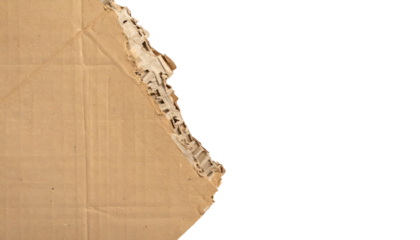 A torn cardboard edge reveals the corrugated interior against a stark black background