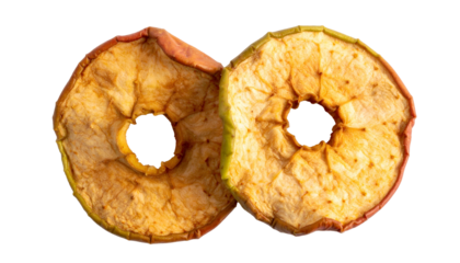 Two dehydrated apple slices with holes, isolated on a black background, close-up