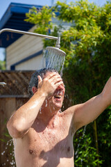man has a shower in the garden