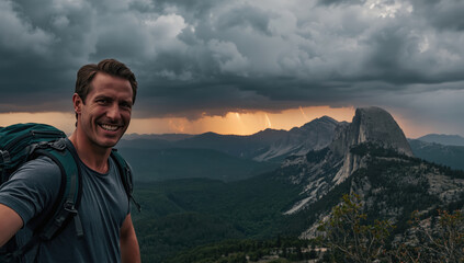 Naklejka premium Smiling hiker with backpack on mountain overlook at dramatic stormy sunset