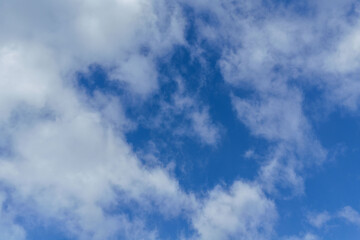 Aerial view of a bright blue sky filled with soft white clouds, creating a calm and open atmosphere ideal for weather concepts, natural backgrounds, seasonal transitions, or clean visual backdrops.