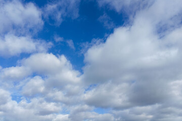 Aerial view of a bright blue sky filled with soft white clouds, creating a calm and open atmosphere ideal for weather concepts, natural backgrounds, seasonal transitions, or clean visual backdrops.
