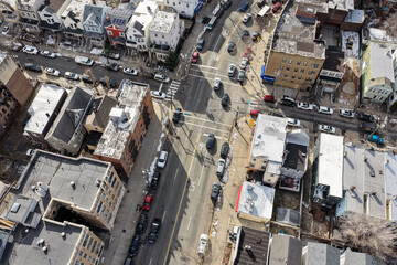 Aerial drone views looking straight down over Jersey City streets reveal dense urban patterns, intersecting roads, rooftops, and city blocks, showcasing the scale, layout, and everyday rhythm 