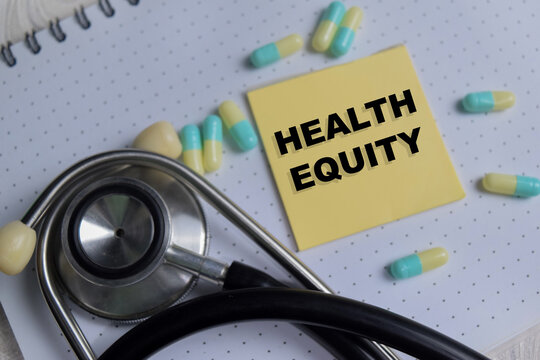 Concept of health equity write on sticky notes isolated on Wooden Table.