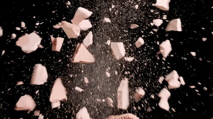 slow-motion extreme detailed shot of two pieces of pressed beige powder colliding and crashing on black background | advertising concept for powder foundation